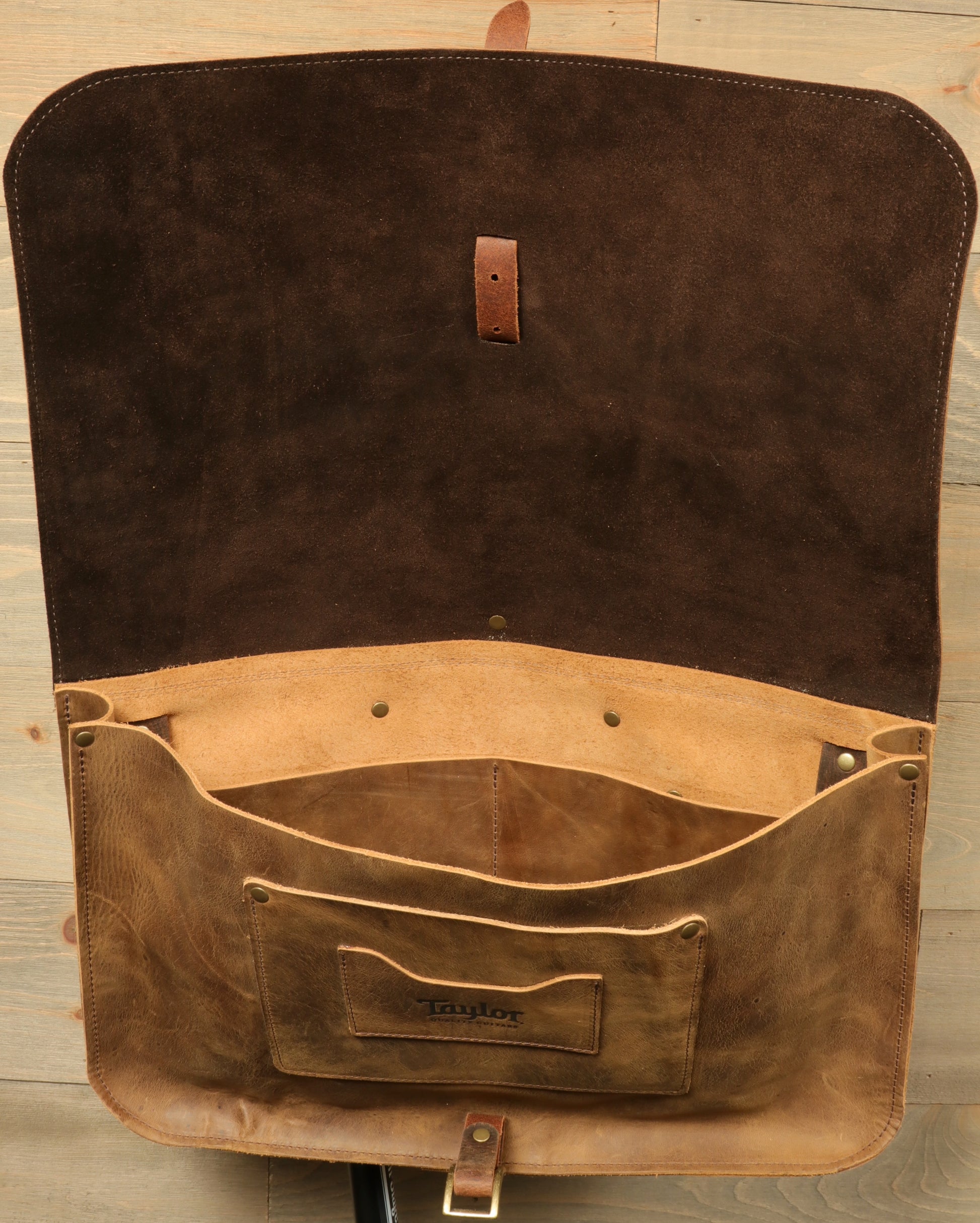 Open Taylor Guitars messenger bag featuring a spacious interior and soft suede lining for musicians