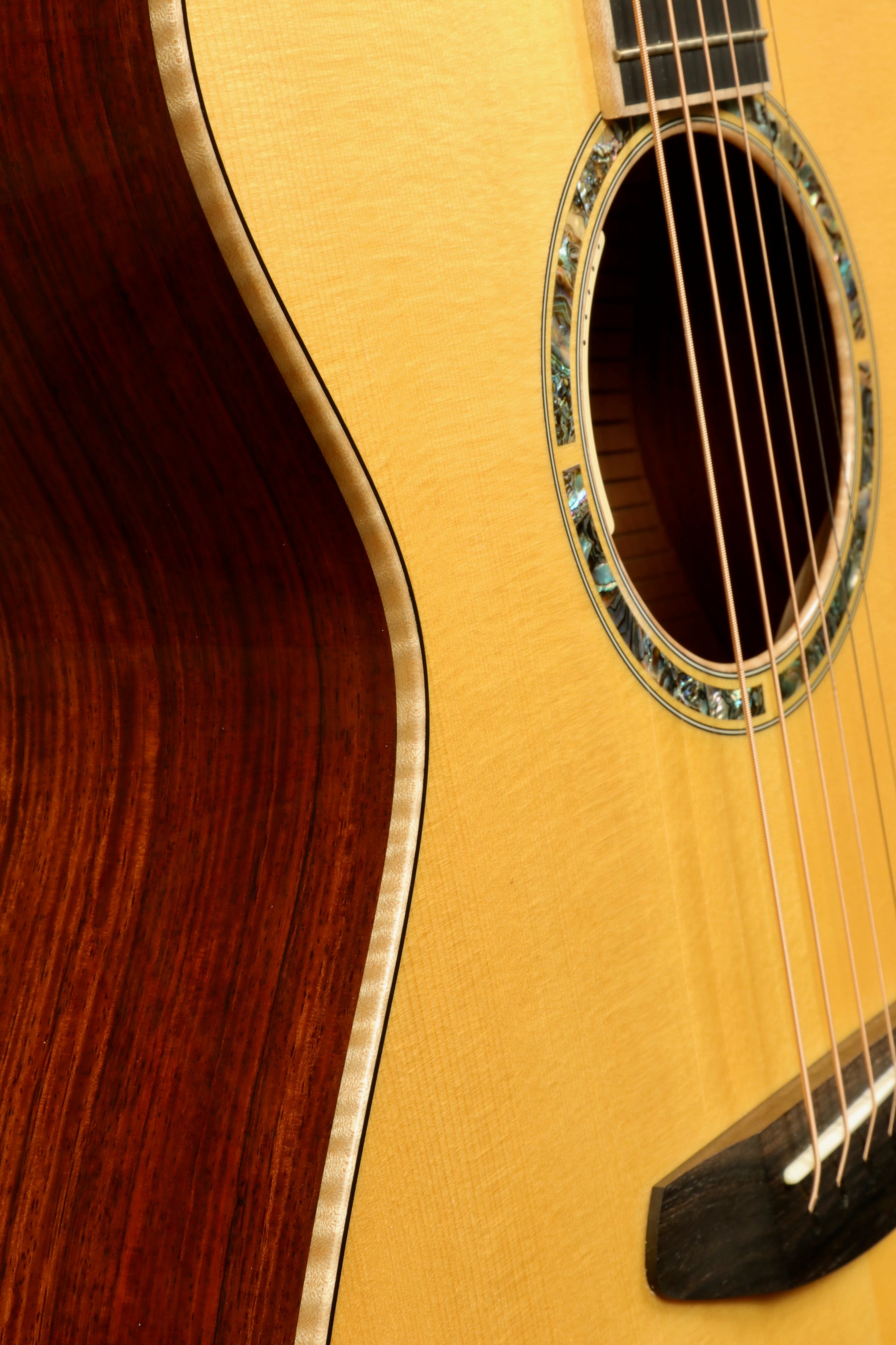 Side view of a used Breedlove Masterclass Concert guitar showcasing its beautiful wood grain and intricate rosette