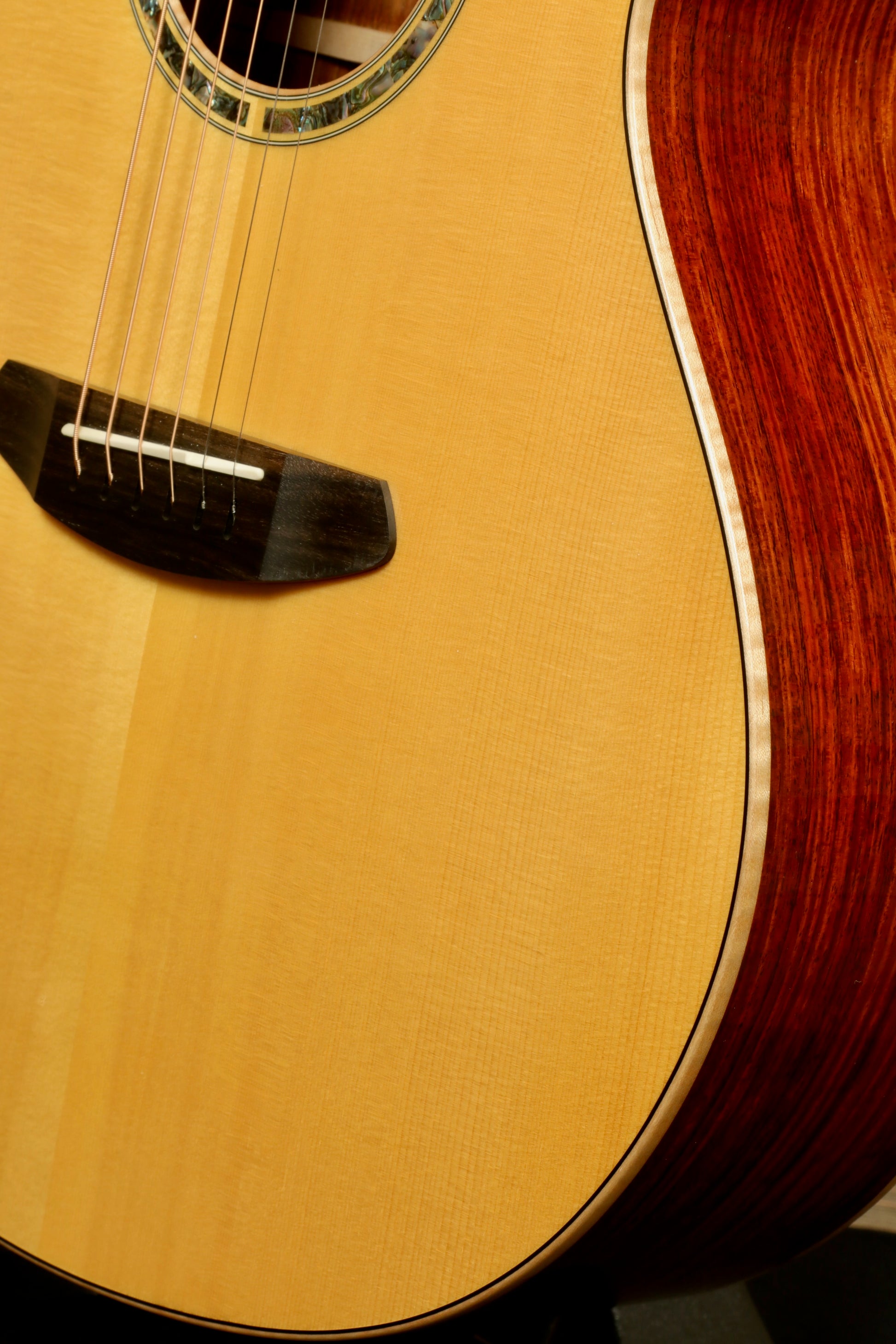 Close-up of a used Breedlove Masterclass Concert guitar showcasing its elegant wood grain and polished finish