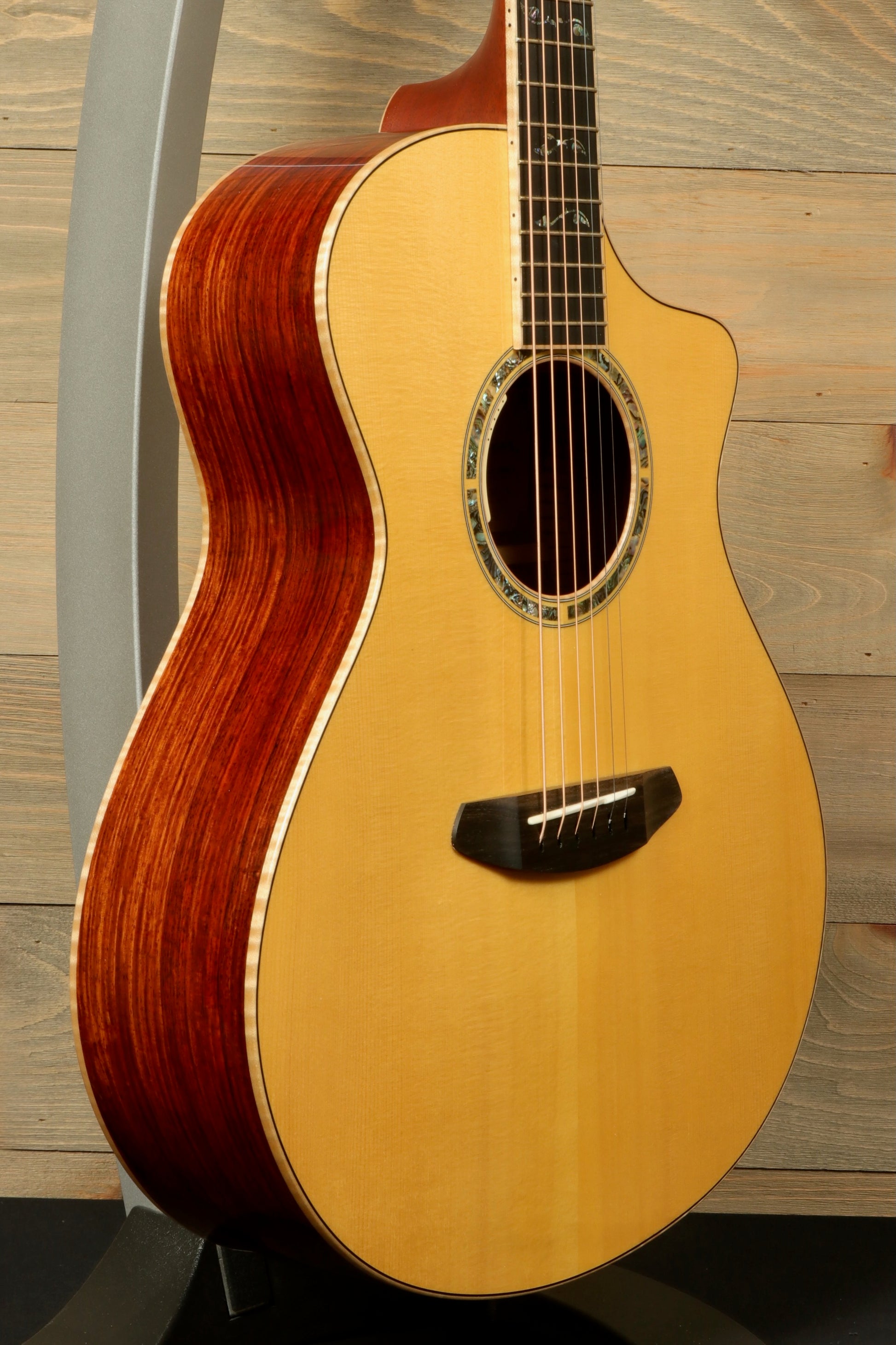 Side view of a used Breedlove Masterclass Concert guitar with a solid top and rosewood back.