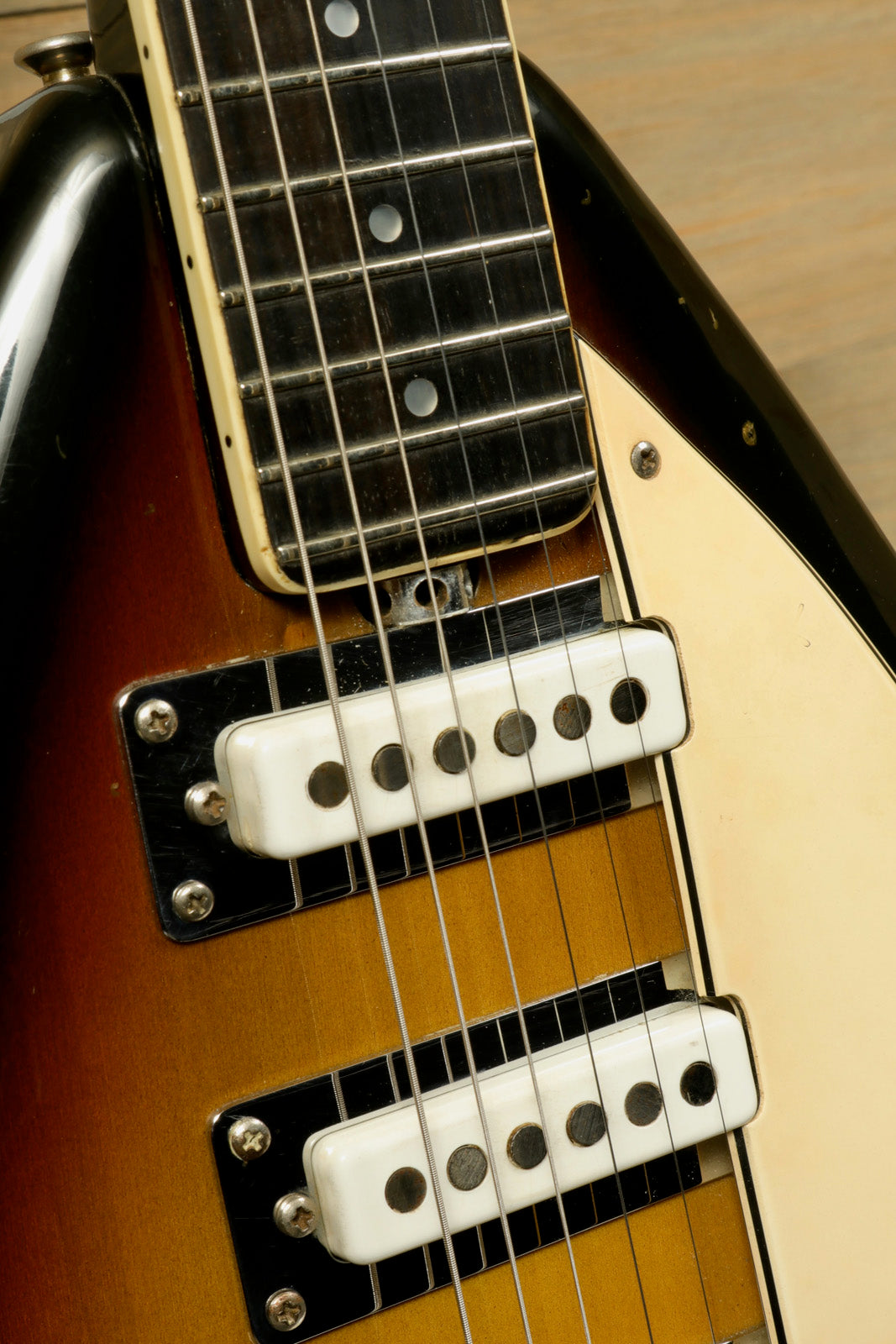 Vox electric guitar in sunburst finish with white pickups, close-up view showcasing the fretboard