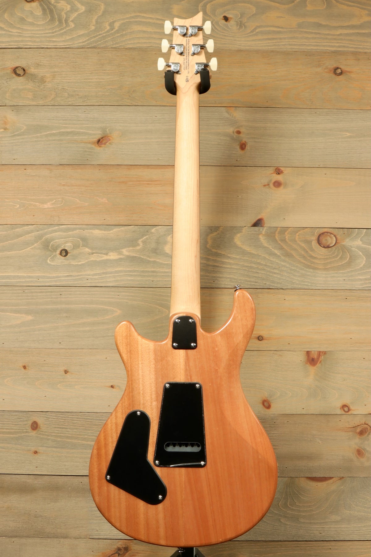 PRS SE electric guitar, natural wood finish, back view showcasing the body and neck