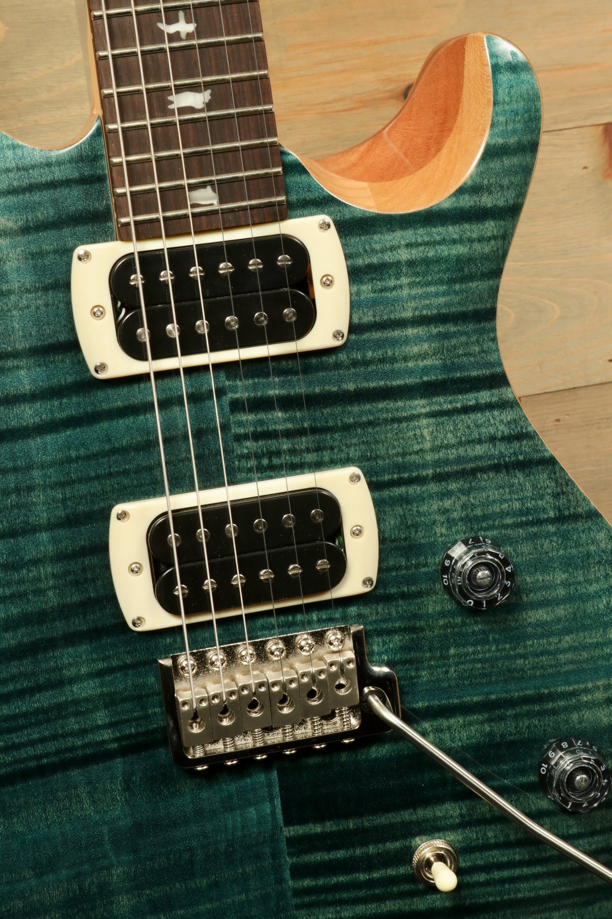 PRS electric guitar in teal blue, showcasing dual pickups and detailed fretboard, top view