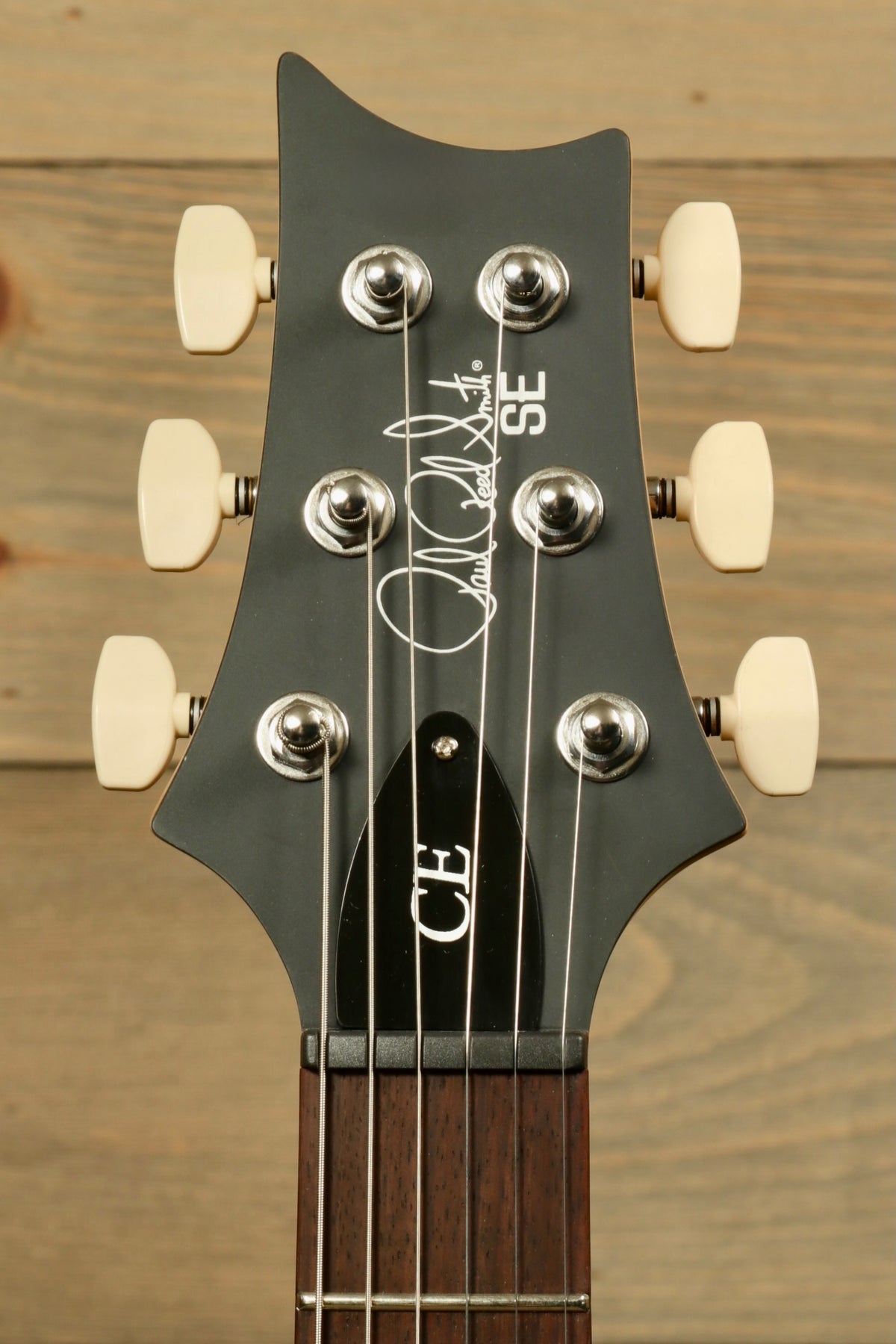 PRS SE CE24 guitar headstock in black with cream tuning pegs, top view