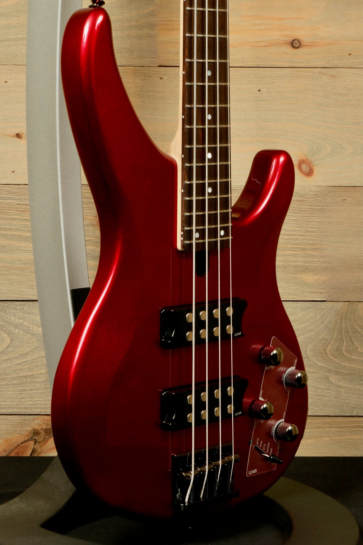 Yamaha electric bass and guitar in metallic red, side view showcasing sleek body and control knobs