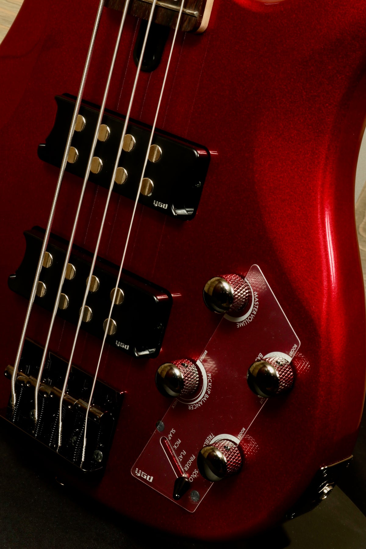 Yamaha electric bass and guitar in red finish, showcasing knobs and pickups from a close-up view
