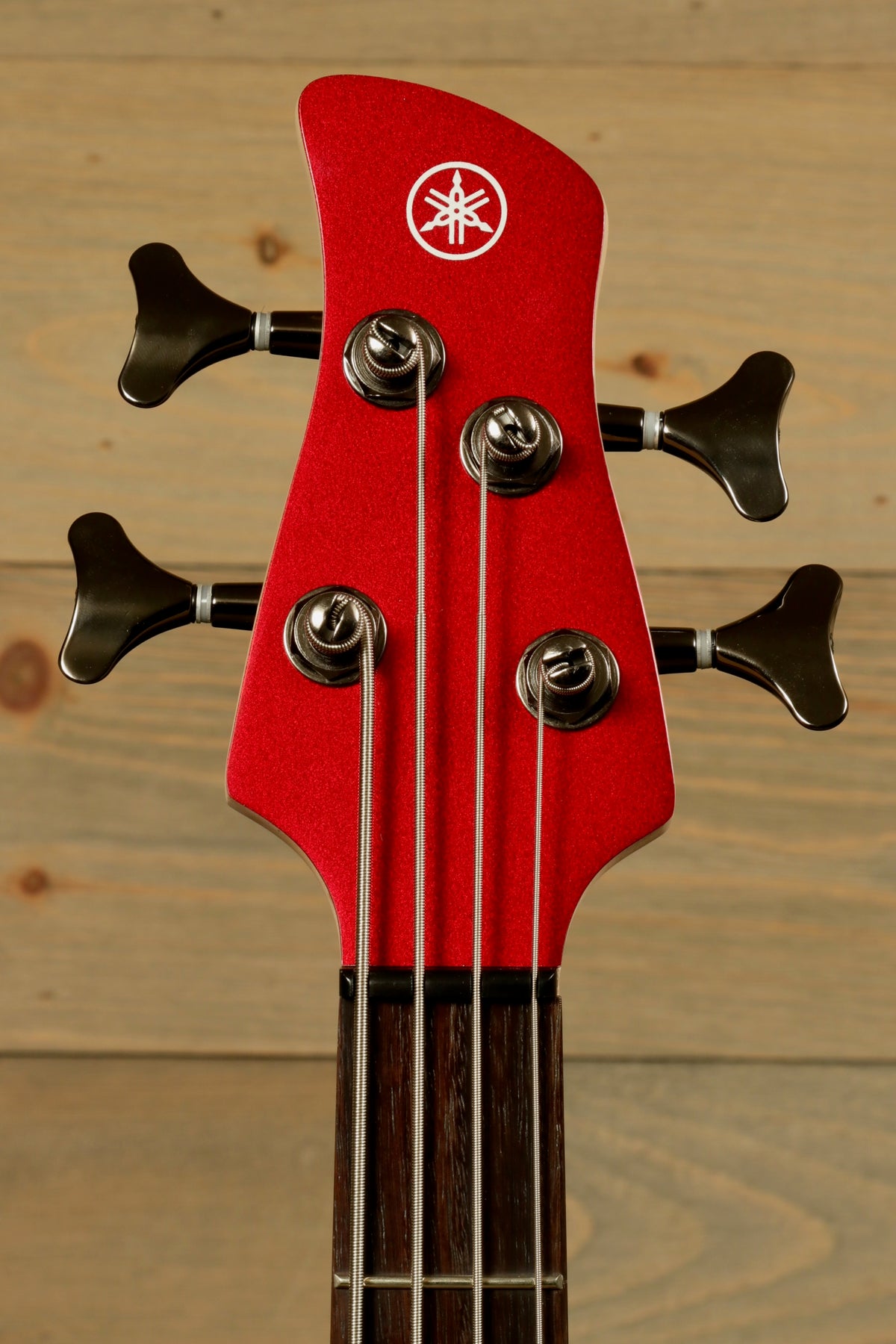 Yamaha electric bass and guitar, red headstock view with tuning pegs and logo