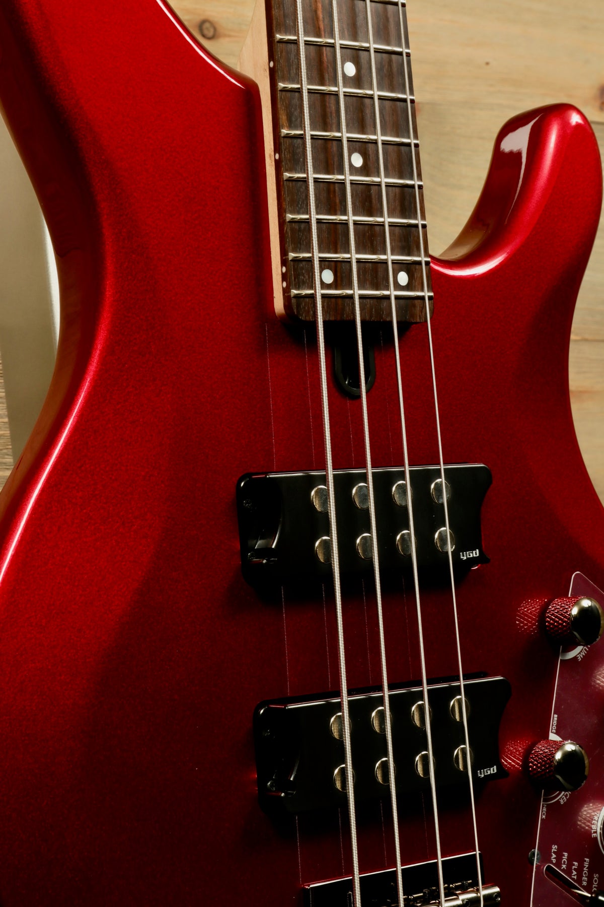 Yamaha electric bass and guitar in metallic red finish, close-up view highlighting the pickups and neck
