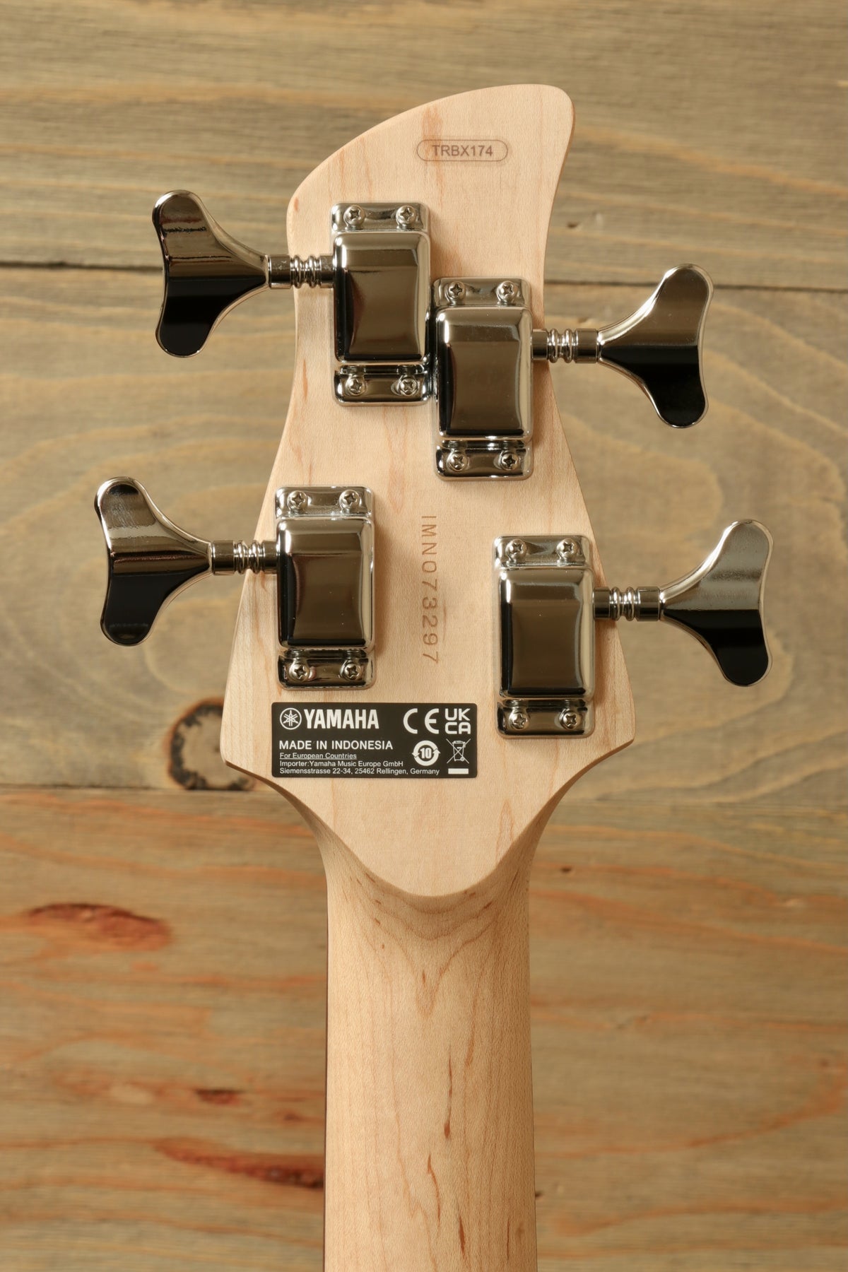 Yamaha TRBX174 natural wood finish bass guitar, back view with tuning pegs