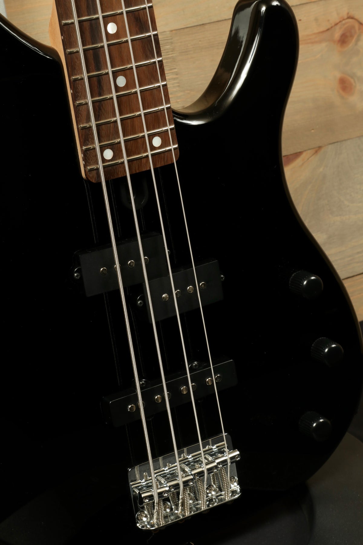 Yamaha TRBX174 black bass guitar, front view showing neck and bridge details