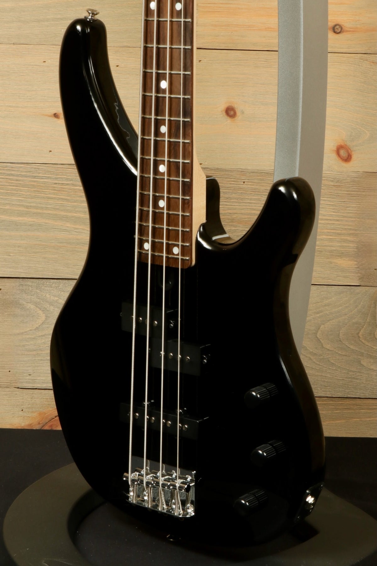 Yamaha TRBX174 bass guitar in black, side view showcasing the sleek body and fingerboard