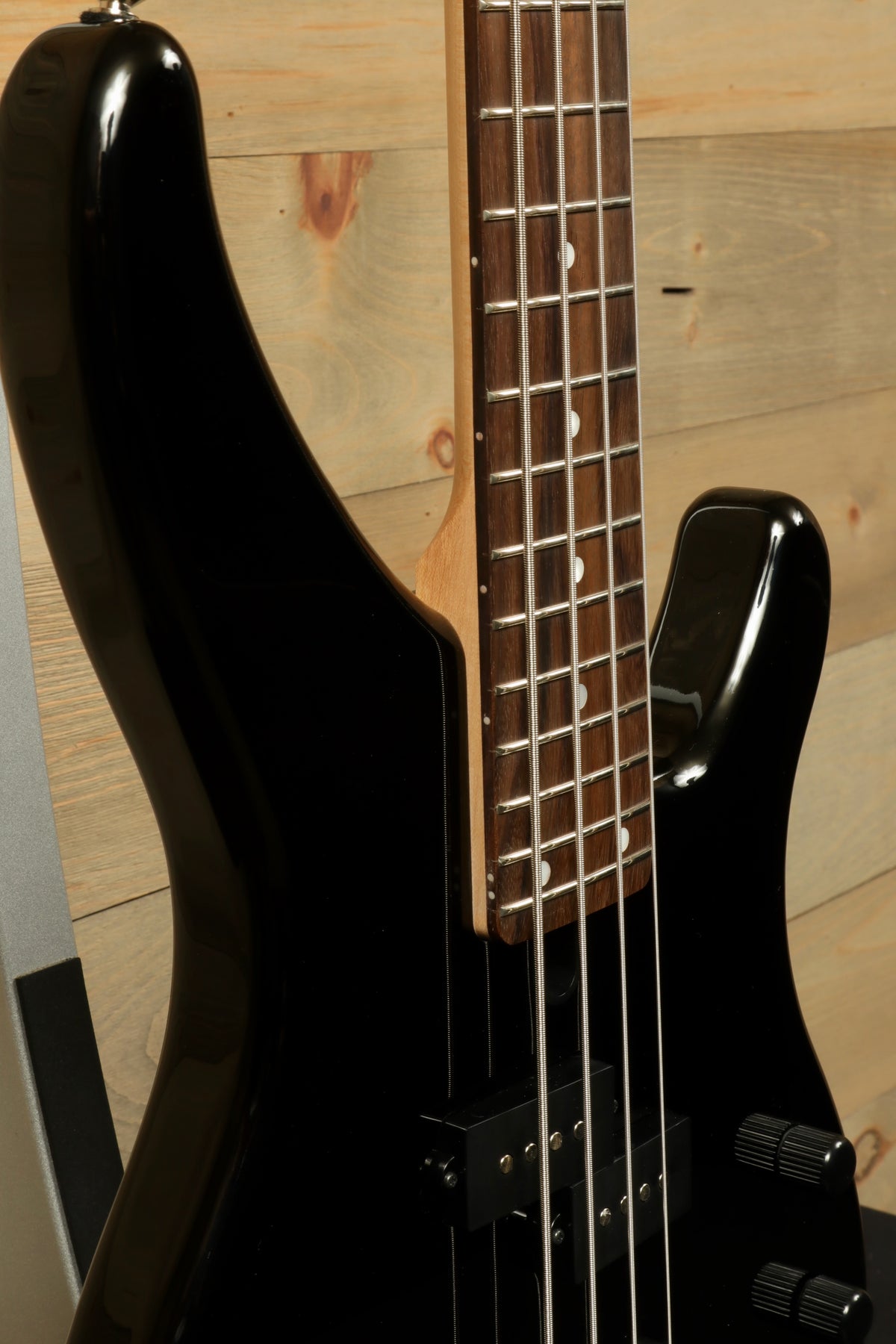 Yamaha TRBX174 electric bass guitar in black with a sleek finish, side view showing neck and body