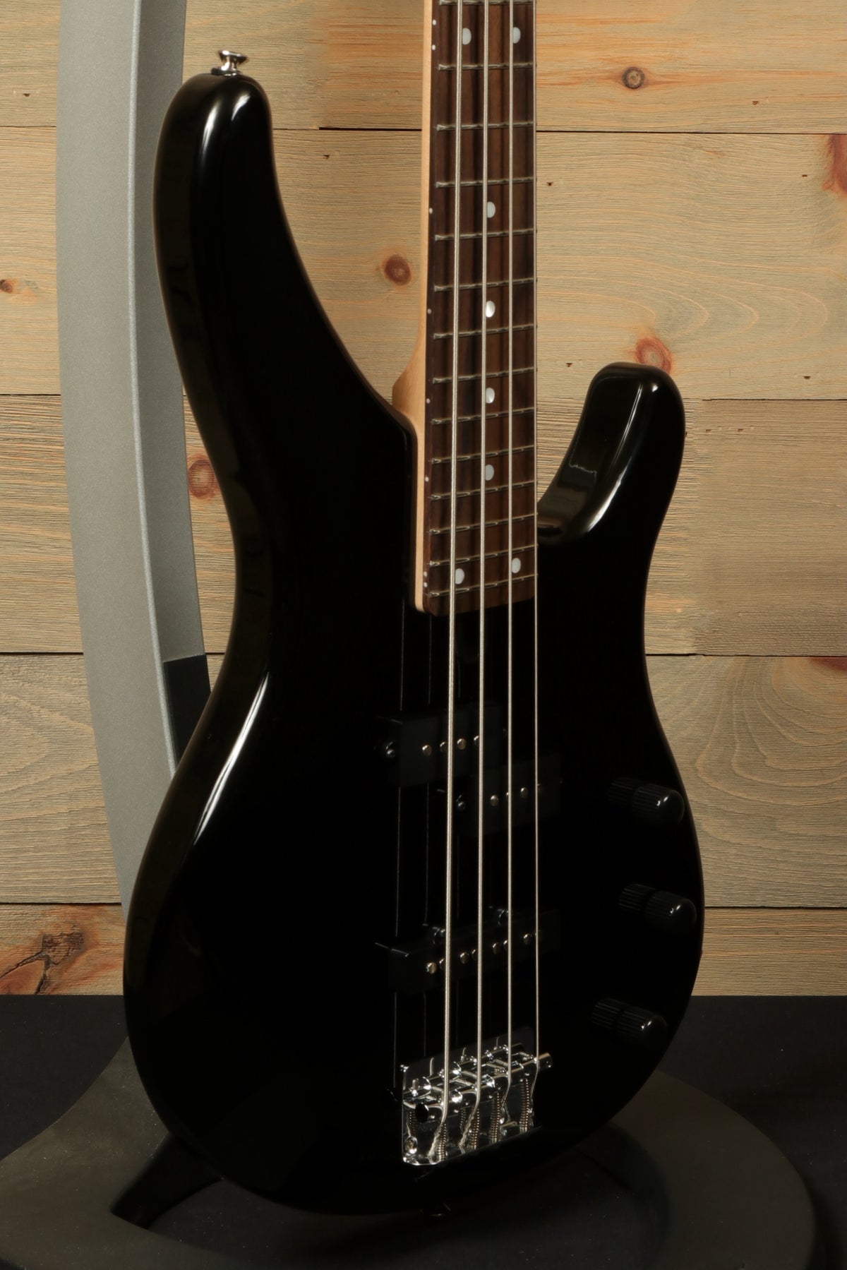 Yamaha TRBX174 bass guitar in black, side view showcasing its sleek design and finish